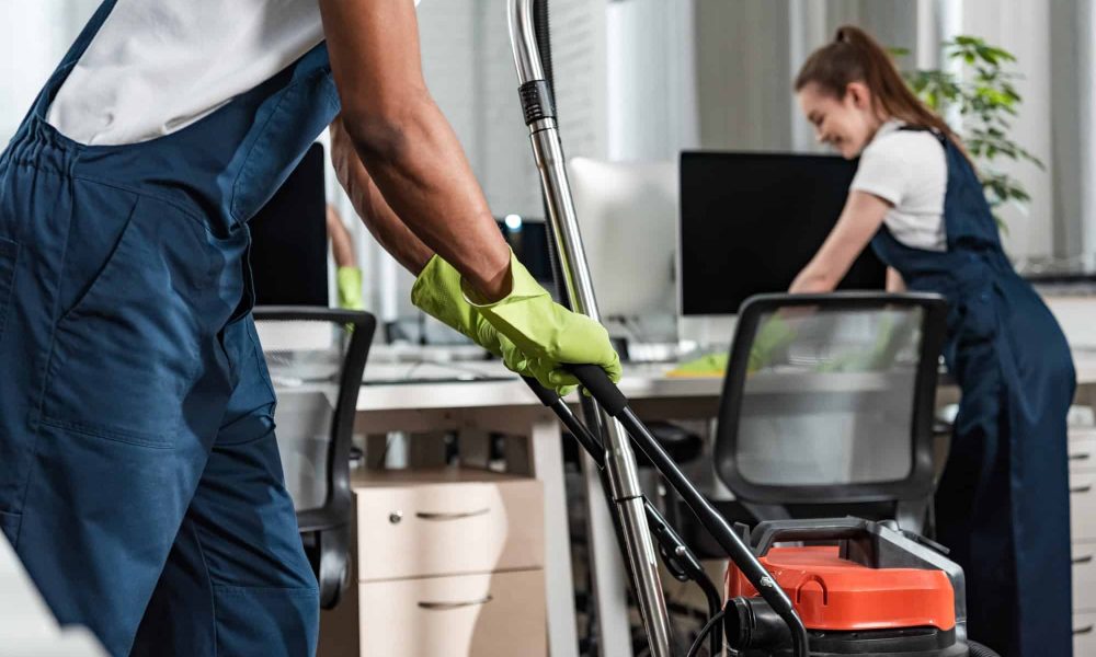 cropped-view-of-african-american-cleaner-moving-vacuum-cleaner-in-office.jpg